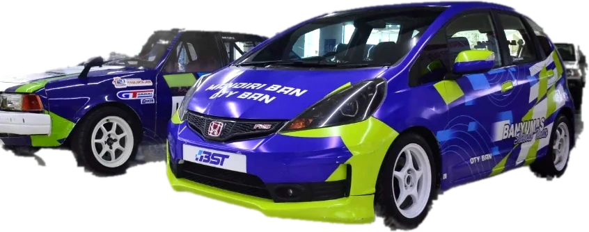 Dua mobil balap Banyumas Slalom Team berlivery biru dan hijau stabilo, dipamerkan berdampingan