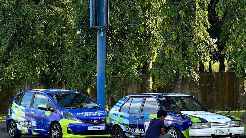 Dua mobil tim diparkir berdampingan saat persiapan di paddock