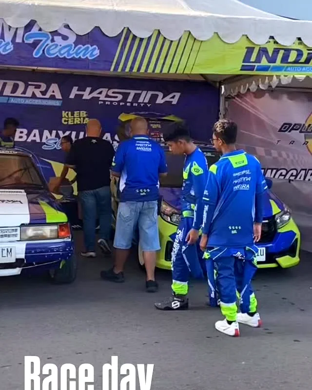 Anggota tim dan mobil balap di area lomba Sirkuit Mandala Krida