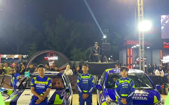 Anggota tim berfoto bersama di lokasi lomba pada malam hari